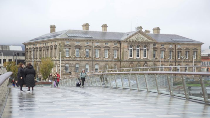 People walking across a bridge in Belfast