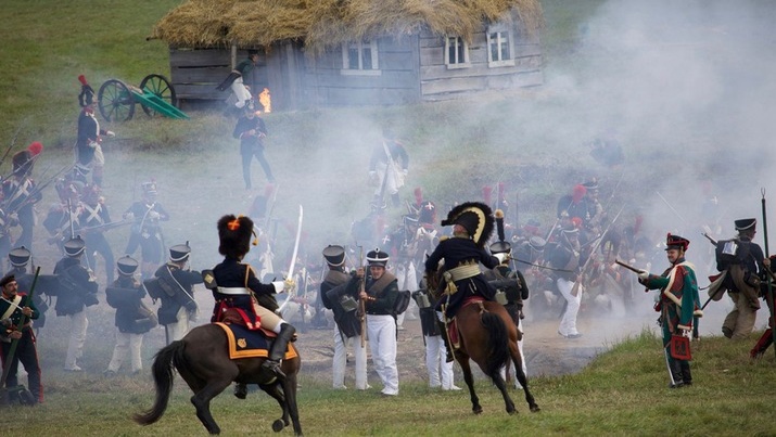 Historical battle reenactment with soldiers and horses.